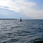 The finish line for the challenge is the red “R2” entrance buoy entering Erie harbor extending south to shore. This is the buoy as I finished.<br><br><i>Lawrence, the bastard, completed the LESC and became a member of the GLSS in 2018. I drove up to Erie when he arrived to welcome and congratulate him with a bottle of Scotch. I was invited to the luncheon on Wednesday where during Lawrence’s speech, I agreed – in front of everyone – to attempt the LESC in 2019. </i>